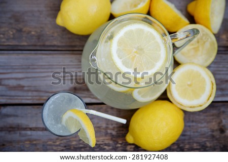 Pitcher of lemonade on a wooden background. Top view, selective focus and space for inscriptions
