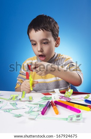Studio shot of four years old kid who have inspiration for his new drawing.