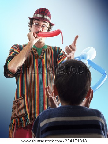 Studio shot of balloon twister who blowing balloon and entertaining child in his birthday party.