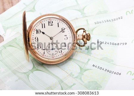 Time is money concept with euros and golden pocket watch.