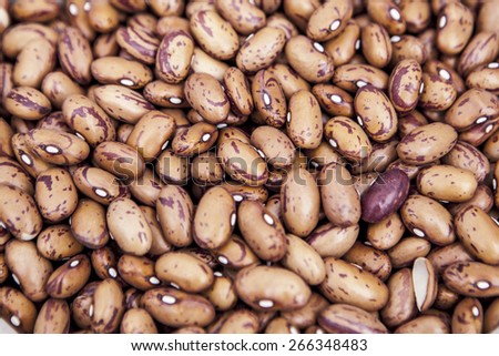 a pile of dried pinto beans for sale in a marketplace