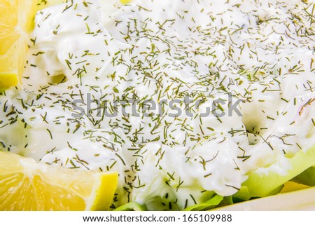 sour cream covered with dill and lemon aside