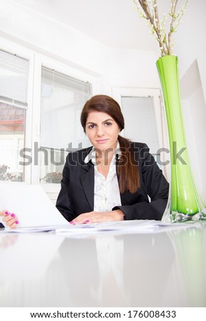 business woman in the house sitting at the desk with papers