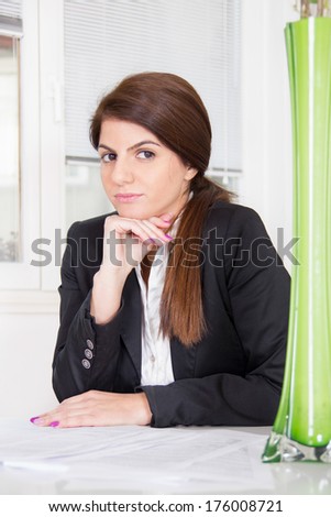 business woman in suit sitting with hair tied in ponytail