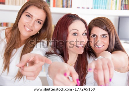 three happy girls pointing fingers at you choosing with a smile