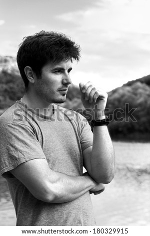 handsome man on summer vacation relaxing at the lake thinking in black and white style