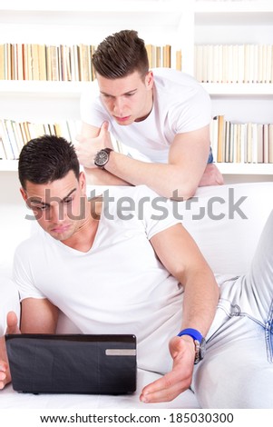 two surprised young people looking at laptop, having problem over the internet