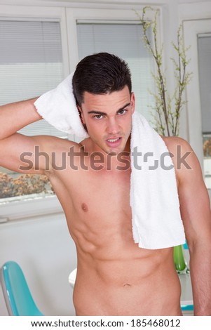 sexy male model with towel wrapped around his neck drying hair