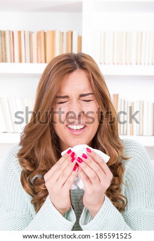 sick woman sniffles with flu virus feeling ill sneezing into tissue