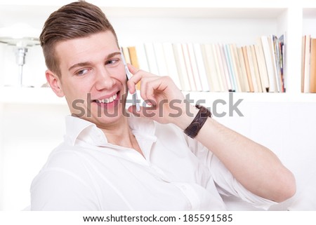happy handsome man talking on the phone in white t-shirt smiling