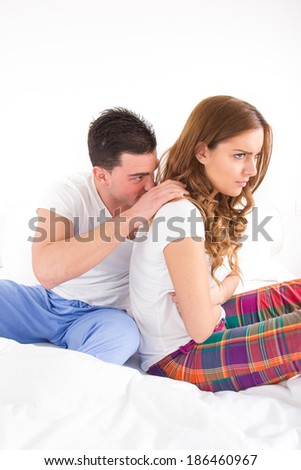pretty young woman ignoring her man partner in her bed during a conflict