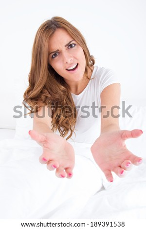 young beautiful casual woman with face expression asking for help with both hands in front of camera
