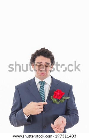 adult sad and very disappointed man in suit with face expression showing with his hand rose flower which is in his jacket pocket