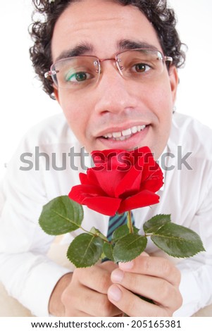 Romantic silly man in love holding red rose, Guy with puppy look offering a rose wearing glasses, Flirty cute guy with flower