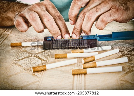 Male hands making cigars with rollings filled with tobacco to satisfy his habit and to smoke handmade cigarettes
