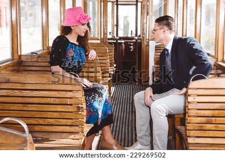 fashion man in suit in the wagon train with woman look at each other face to face , love talk of couple on train , vintage retro fashion photo