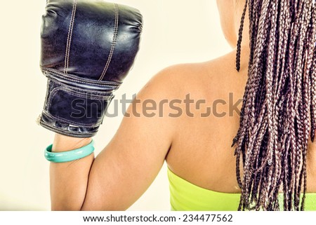 Photo of woman from behind showing black boxing glove , strength, power or competition concept , ready to fight for love