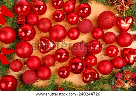Christmas decoration with many scattered red round ornaments for Christmas tree. Holiday decorations on brown wooden background
