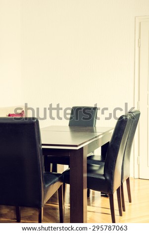 Dining room interior with table and four black chairs near kitchen. Breakfast Area spot. Space for work and business meetings with clients and people. Indoor photo