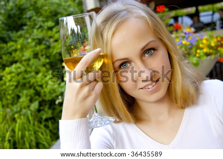 Beautiful lady in the restaurant with a glass of wine.