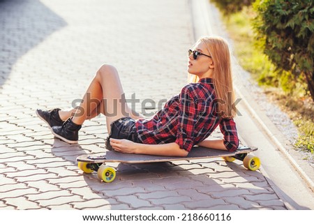 Sport fashion girl posing in summer with skateboard