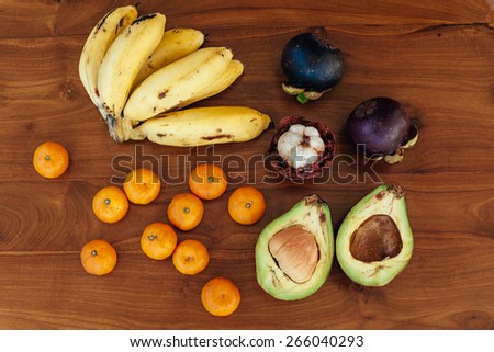 Set of exotic tropical fruits with big pineapple on background lie on wooden table