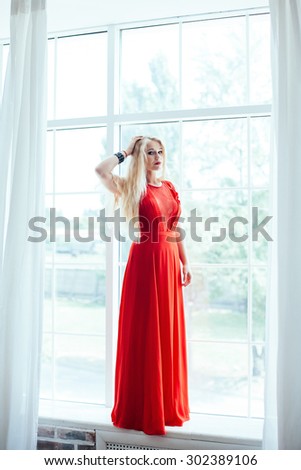 full-length portrait of young beautiful blonde woman with red lips