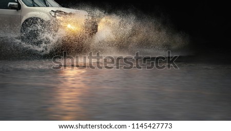 Stop motion, high resolution image of \
 splash by a car through flood water after hard rain.