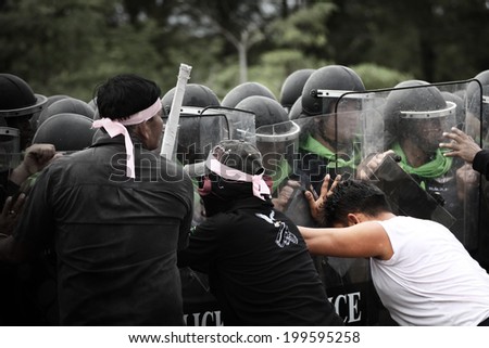BANGKOK THAILAND-DECEMBER 10 :  Unidentified  protester push the Police in Riot Gear during a violent anti-government on dec 10, 2013 in Bangkok, Thailand.