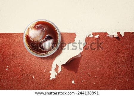 Iced coffee and ices in heart shape on cracked concrete floor, background for valentine\'s day.