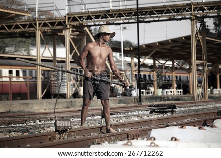 Suratthani,Thailand,April 8,2015 : Worker with tools repair rail lines on Suratthani train station.