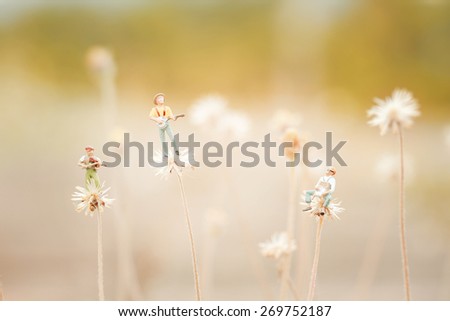 Group of friends playing music on the flower like Dandelion.Close up of miniature, Shallow depth of field composition and soft pastel color.