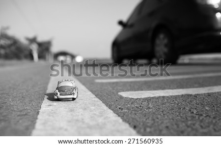 Taxi toy model on country road background. Shallow depth of field composition and Black & White.