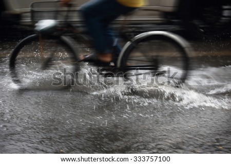 Splash by a bike through flood water after hard rain,blurry movement  and selective focus.