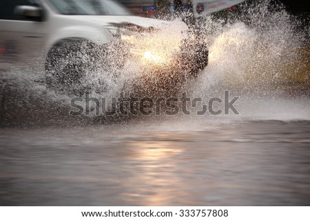 Splash by a car through flood water after hard rain,blurry movement  and selective focus.