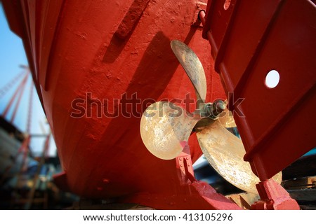 Lower part of stern and propeller of a fishing boat in a shipyard for maintenance.