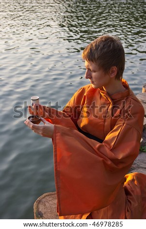master of tea ceremony with cup in hands near the water