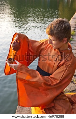 master of tea ceremony with cup in hands near the water