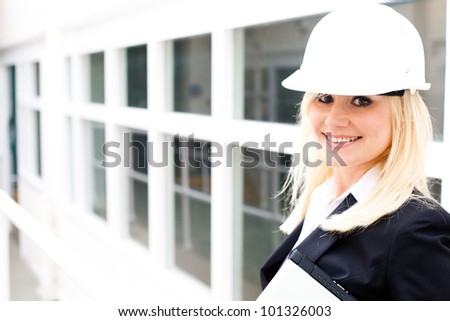 Young woman engineer wearing a safety hardhat inspecting work at the job site