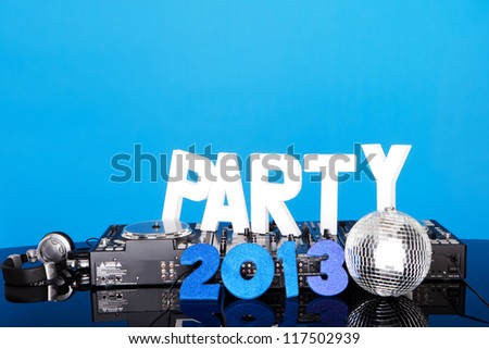 PARTY 2013 background with DJ music mixing deck, mirrored disco ball and lettering against a blue background with copyspace