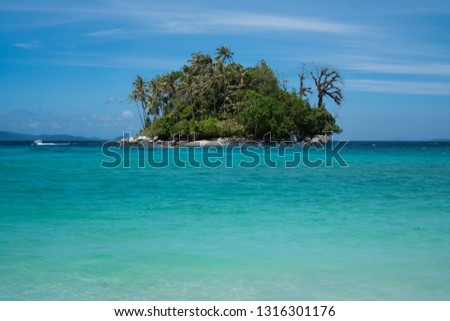 Seascape with small island over blue summer sky background. Paradise beach on small island
