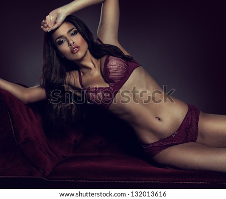 Sexy, Sultry Woman Posing In Purple Lingerie On A Purple Couch