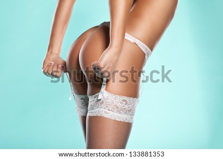 Torso portrait of a slender woman wearing stockings and suspenders displaying her sexy bum