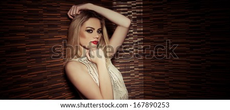 Beautiful sophisticated glamorous woman wearing makeup and elegant evening wear, upper body portrait against darkness with copyspace