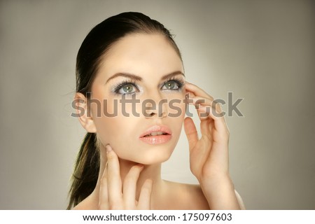 Young woman with beautiful healthy face on grey