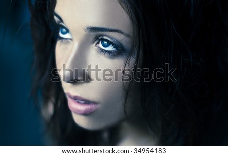 Fantasy glamour portrait of a young beauty with blue eyes