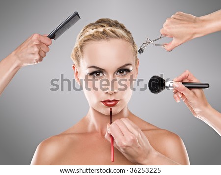 Picture shows studio makeup process hands with brush,lipbrush , lash comb and loose powder brush