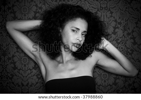 fashion portrait of beauty brunette woman on stylish wallpaper