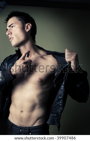 muscular handsome Man with perfume bottle wearing jacket