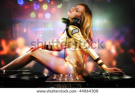 Beautiful DJ girl on decks playing on the party people on the dance floor